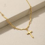 Accessoire tendance, croix dorée et design ondulé