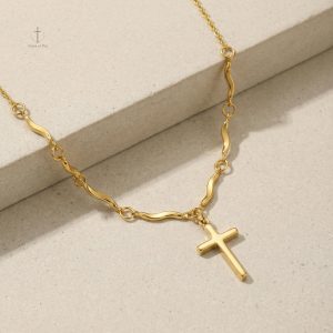 Accessoire tendance, croix dorée et design ondulé