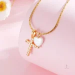 Bijou en croix avec cœur en nacre et pierres brillantes