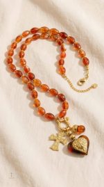 Bijou en rouge avec breloques en croix et cœur
